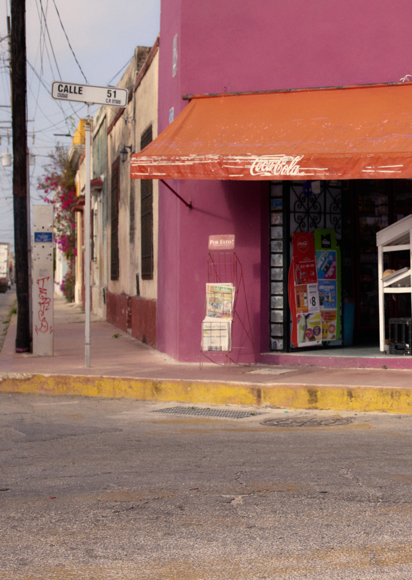 Purple building with red Coca-Cola awning on a street corner